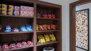 A pantry stocked with various food items including pasta, chips, and snacks.