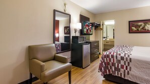 A hotel room with a bed, a desk, a chair, a television, a microwave, and a refrigerator. - Red Roof Inn Shelbyville (Shelbyville)