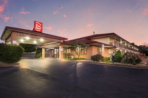 Un Red Roof Inn de dos pisos, con área de estacionamiento techada y una entrada bien iluminada.