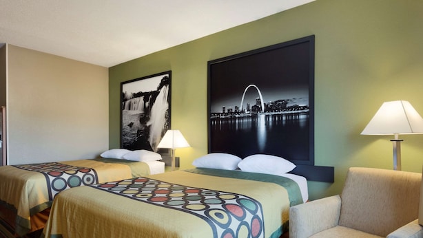 A hotel room with two beds, a chair, a lamp, and two wall art pieces. - Super 8 by Wyndham Lees Summit (Lee's Summit)