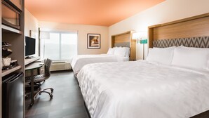 Une chambre d’hôtel avec deux lits, un bureau avec un ordinateur, une chaise et un téléviseur.