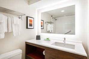 A modern bathroom with a large mirror, white sink, and towel rack. - Holiday Inn Timonium Baltimore North by IHG (Lutherville Timonium)