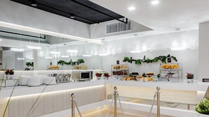 A modern kitchen with white countertops, stainless steel appliances, and hanging plants. - Palazzo Lakeside Hotel (Kissimmee)