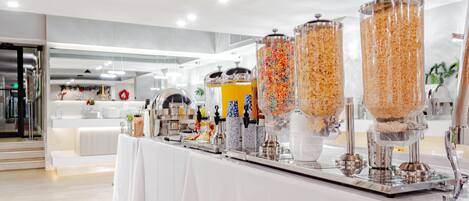 A buffet area with various food dispensers and a clean, modern interior.
