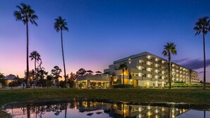 A hotel with a modern design, featuring multiple floors and a reflective pool in front. - Palazzo Lakeside Hotel (Kissimmee)