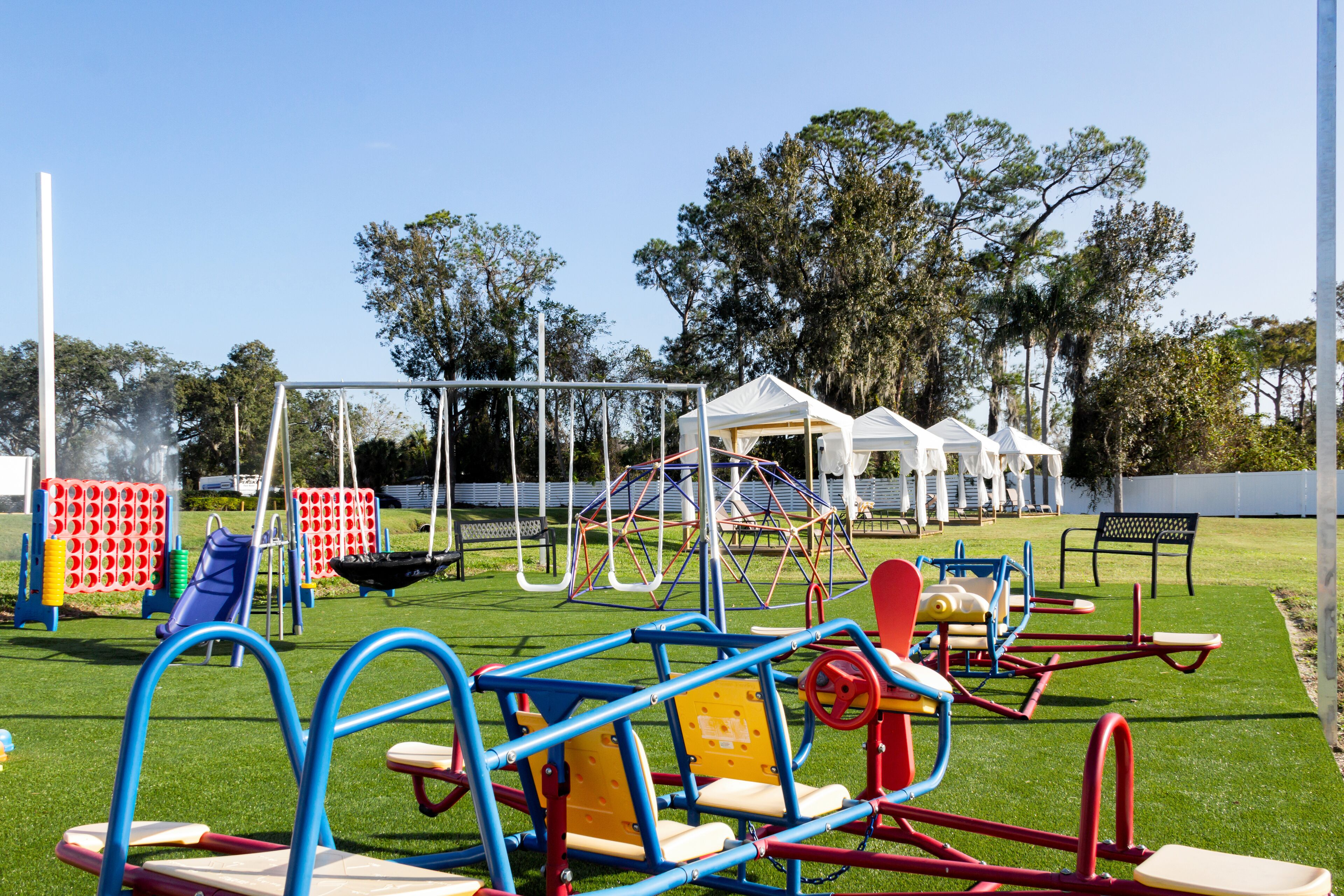 A playground with various play structures including swings, slides, and climbing frames.