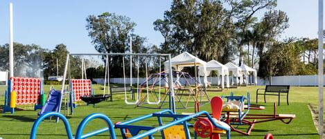 Un parque infantil con diversas estructuras de juego, incluyendo columpios, toboganes y juegos de escalar.