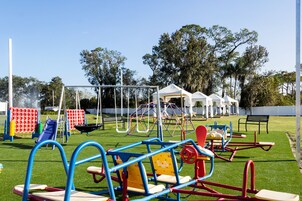 A playground with various play structures including swings, slides, and climbing frames.