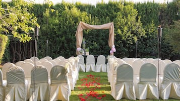 Un pasillo nupcial con sillas y un arco floral.