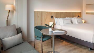 Una habitación de hotel con una cama, un sofá, una mesita y una silla.