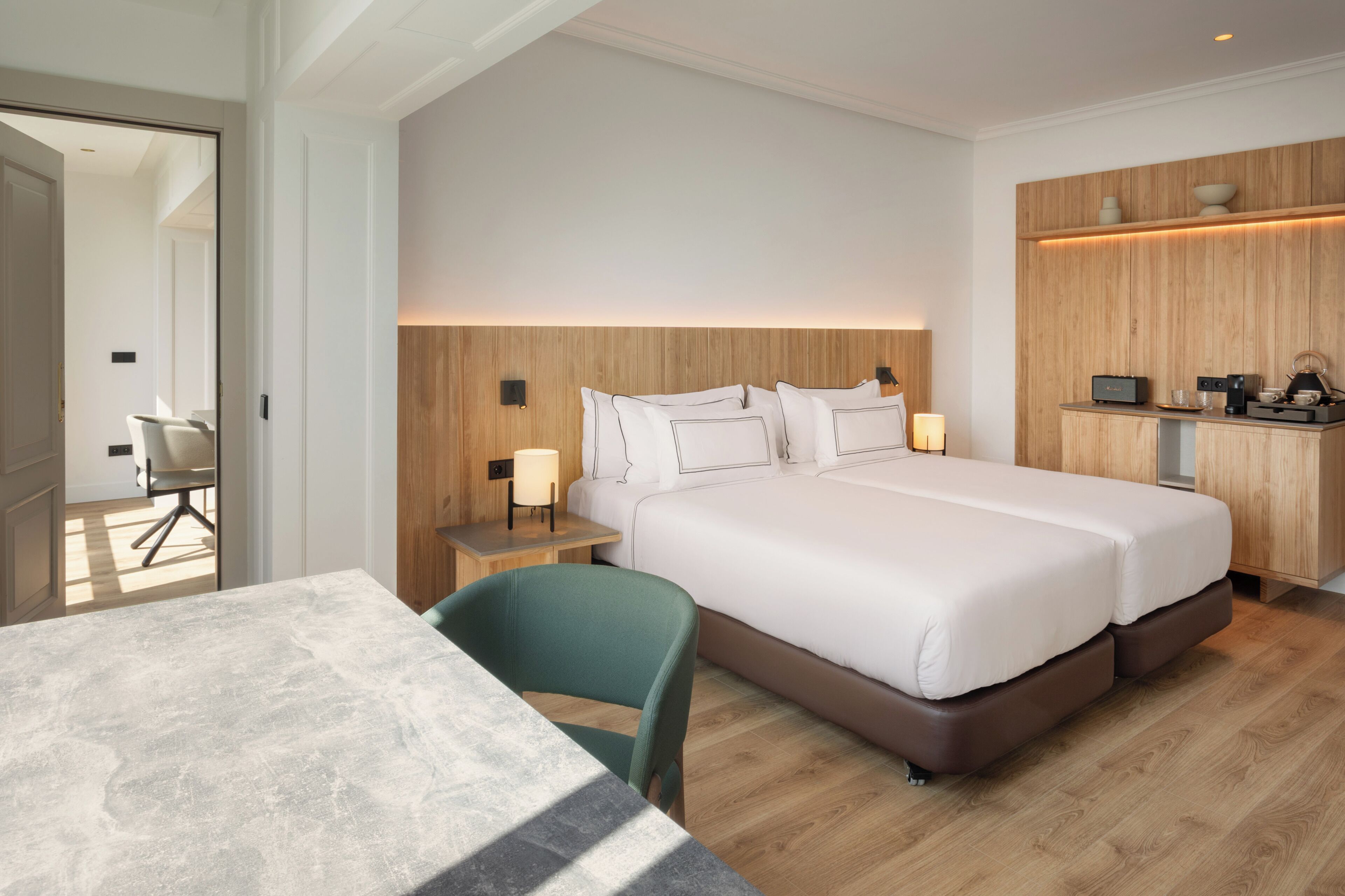 Una camera d'hotel moderna con un letto grande, una scrivania e una sedia.