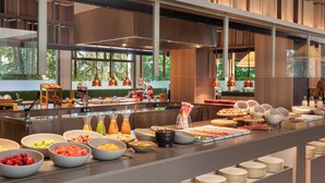 Un bufé con diversos alimentos y una cocina moderna al fondo.