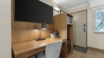 A compact workspace with a desk, chair, and a coffee machine.