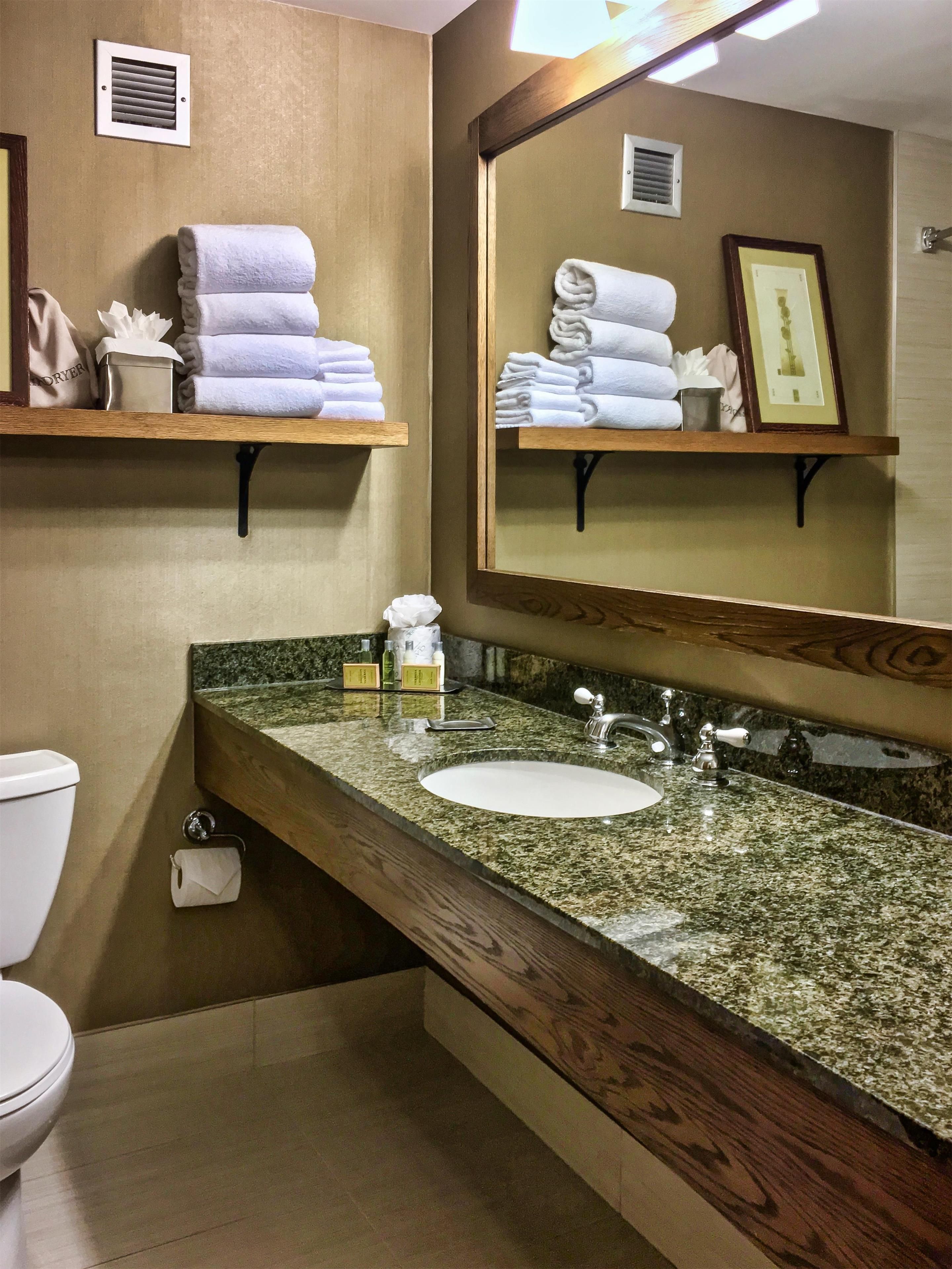 Un baño con inodoro, lavamanos y espacio para toallas.