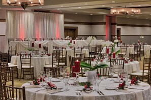 A banquet hall with round tables set for a formal event, featuring white tablecloths, red candles, and floral centerpieces. - DoubleTree by Hilton Libertyville - Mundelein (Mundelein)
