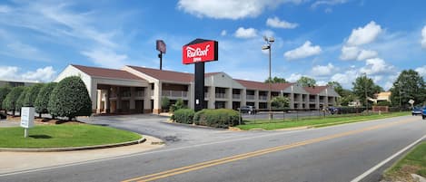 A Red Roof Inn with a drive-thru ATM, a parking lot, and a road with double yellow lines.