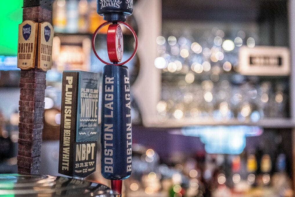 A bar with various beer taps, including Boston Lager and NBPT Brew.
