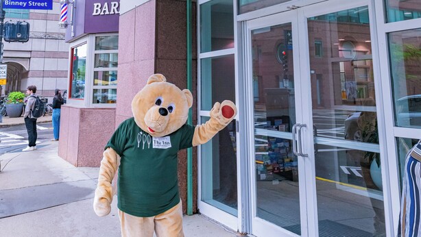 A mascot outside The Inn at Longwood Medical, with a visible entrance and signage for a bar. - The Inn at Longwood Medical (Boston)
