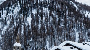 A snow-covered mountain with a ski lift, stone buildings with snow-covered roofs, and a church tower. - Hotel Ormelune (Val-d'Isere)
