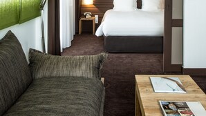 A hotel room with a bed, a desk, a lamp, and a green wall. - Hotel Ormelune (Val-d'Isere)