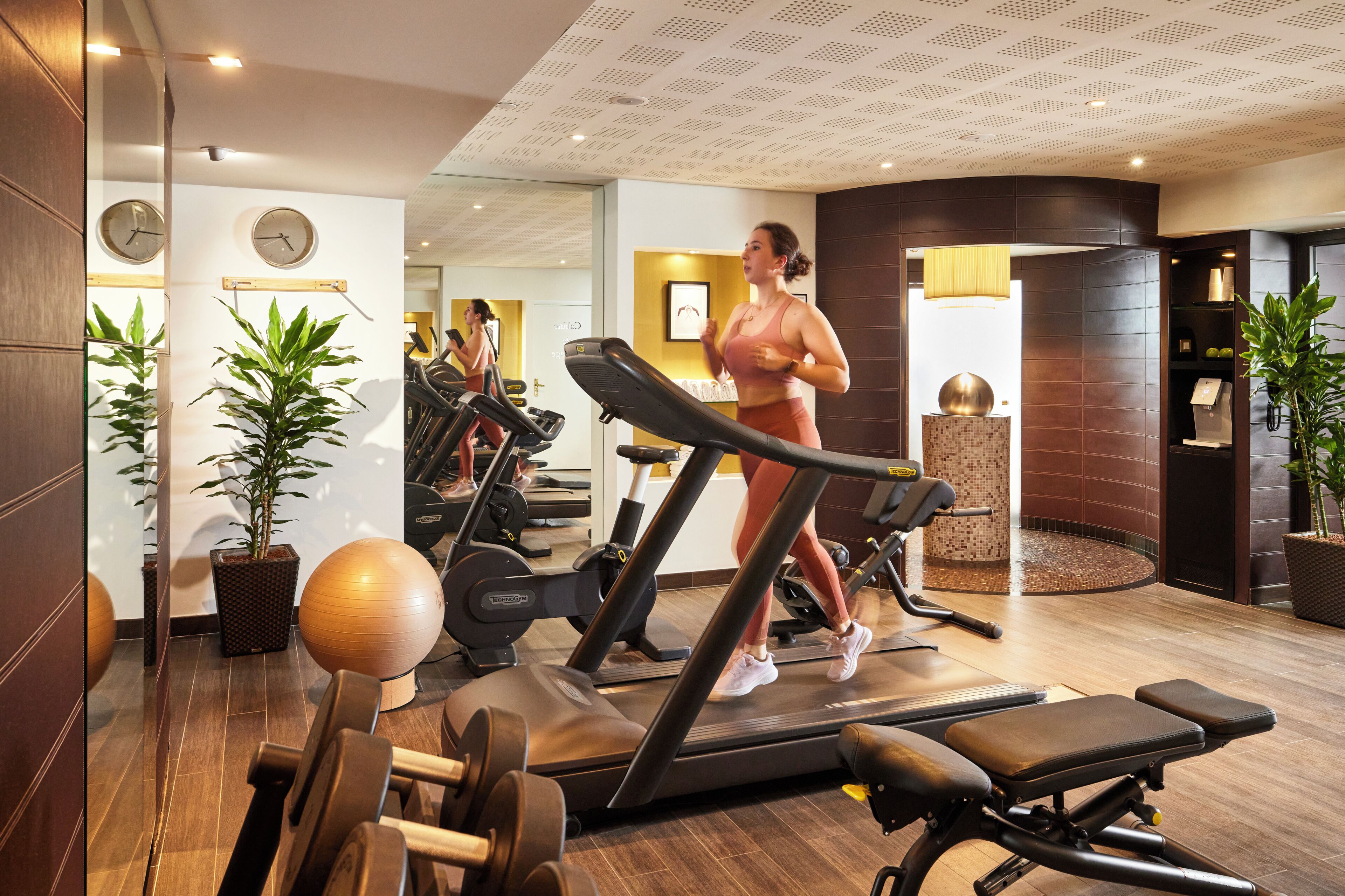 A gym with treadmills, exercise balls, and weight benches.