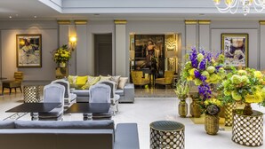 Un vestíbulo amplio con techo alto, muebles elegantes y jarrones decorativos.