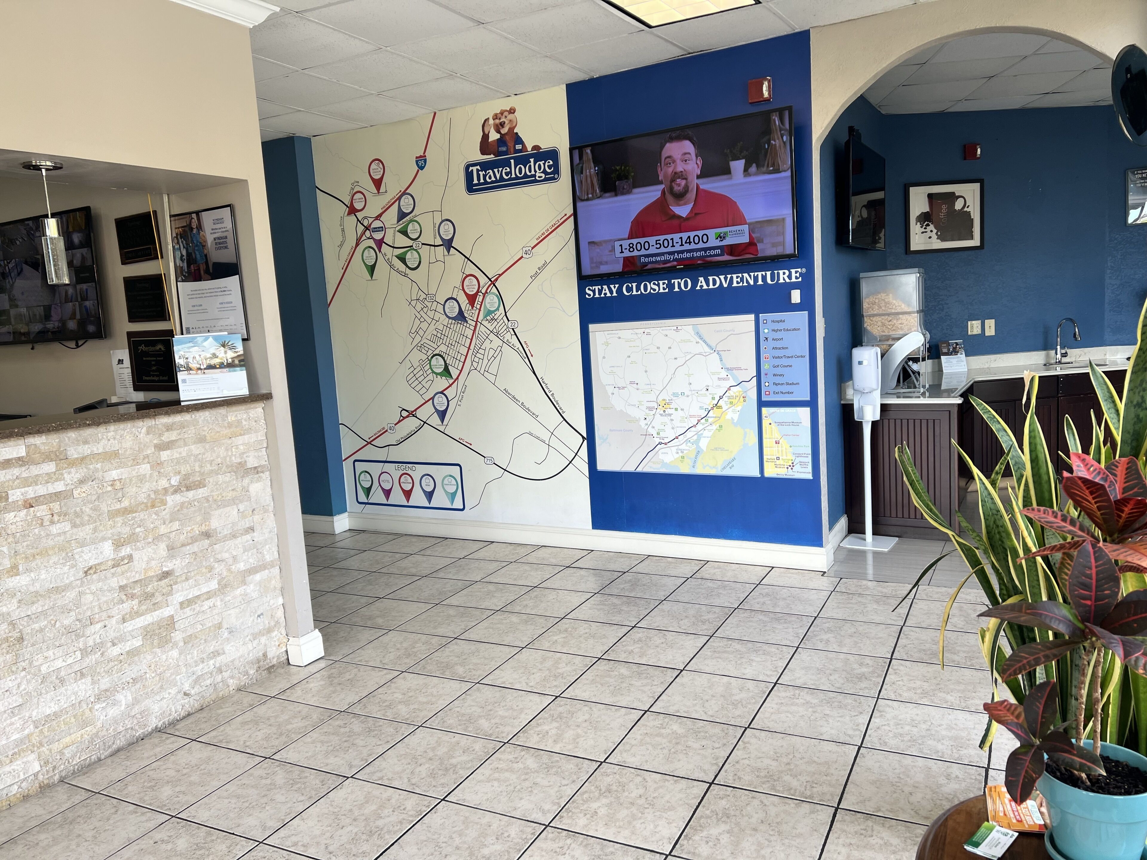 Un espace d’accueil comprenant une grande carte, un écran de télévision et un comptoir.