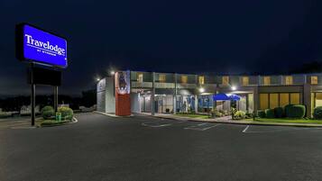 A Travelodge hotel with a modern facade, a prominent sign, and a well-lit entrance.