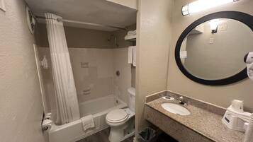 A bathroom with a bathtub, toilet, and sink.