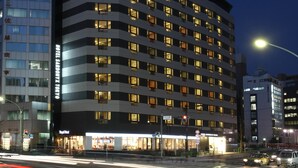Un hôtel à plusieurs étages au design moderne, avec une enseigne bien visible sur le toit.