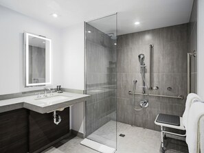 A modern bathroom with a glass-enclosed shower, a vanity with a mirror, and a towel rack. - Novotel Montreal Centre (Montreal)