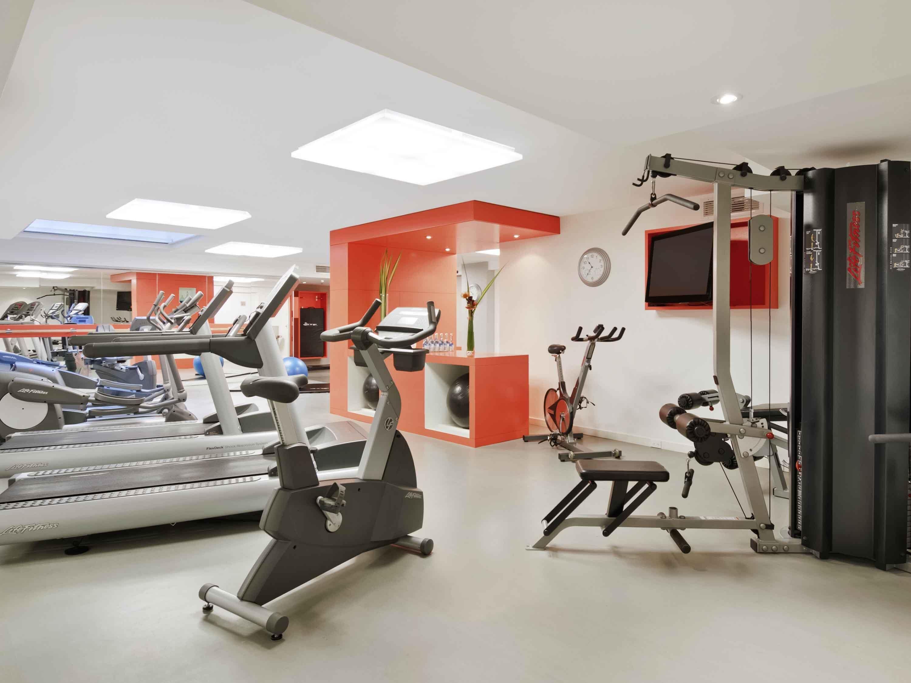 A gym with treadmills, an elliptical, a bike, and a squat rack.