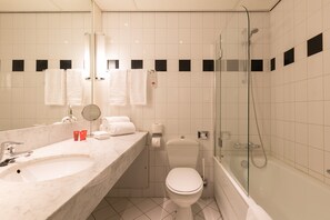A modern bathroom with a marble sink, a toilet, and a glass-enclosed shower. - Leonardo Hotel Lelystad City Center (Lelystad)