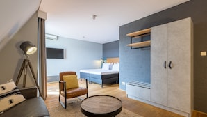 A modern bedroom with a bed, a wardrobe, a desk, and a chair. - Leonardo Hotel Lelystad City Center (Lelystad)