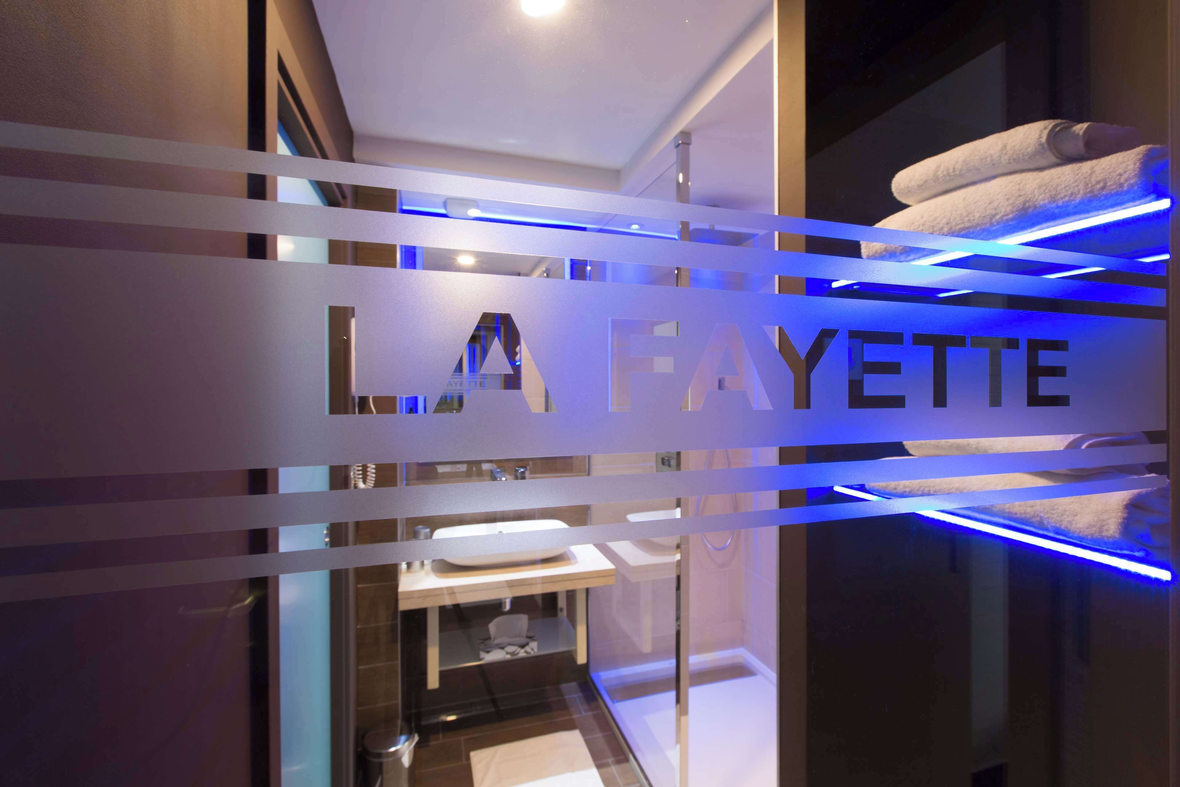 A modern bathroom with a glass partition displaying the name 'LA FAYETTE'.
