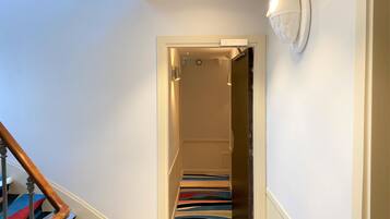 A staircase with a striped carpet leading to a room.