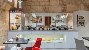 Una cocina moderna con un fondo de pared de piedra, una barra de desayuno y una variedad de alimentos y utensilios a la vista.