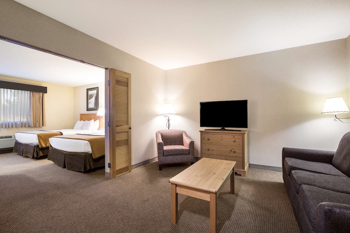 Une chambre d’hôtel équipée d’un lit, d’une télévision, d’un canapé, d’une chaise, d’une table et d’un bureau.