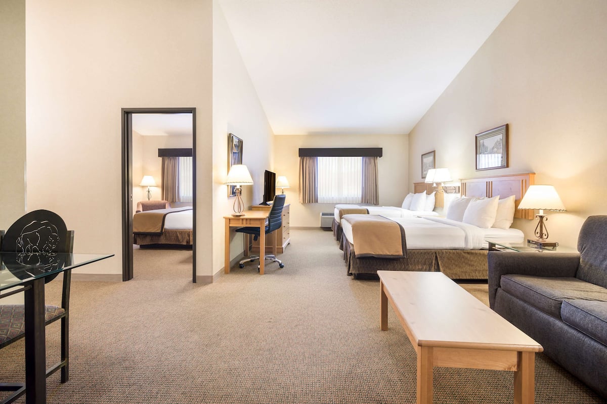 Une chambre d’hôtel avec un grand lit, un bureau, une chaise, un canapé et une petite table.