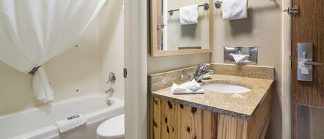 A bathroom with a bathtub, a sink, and a mirror.