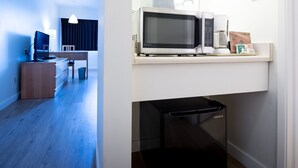 A modern kitchen with a microwave, coffee maker, and a small refrigerator. - Cassandra Hotel (Vancouver)
