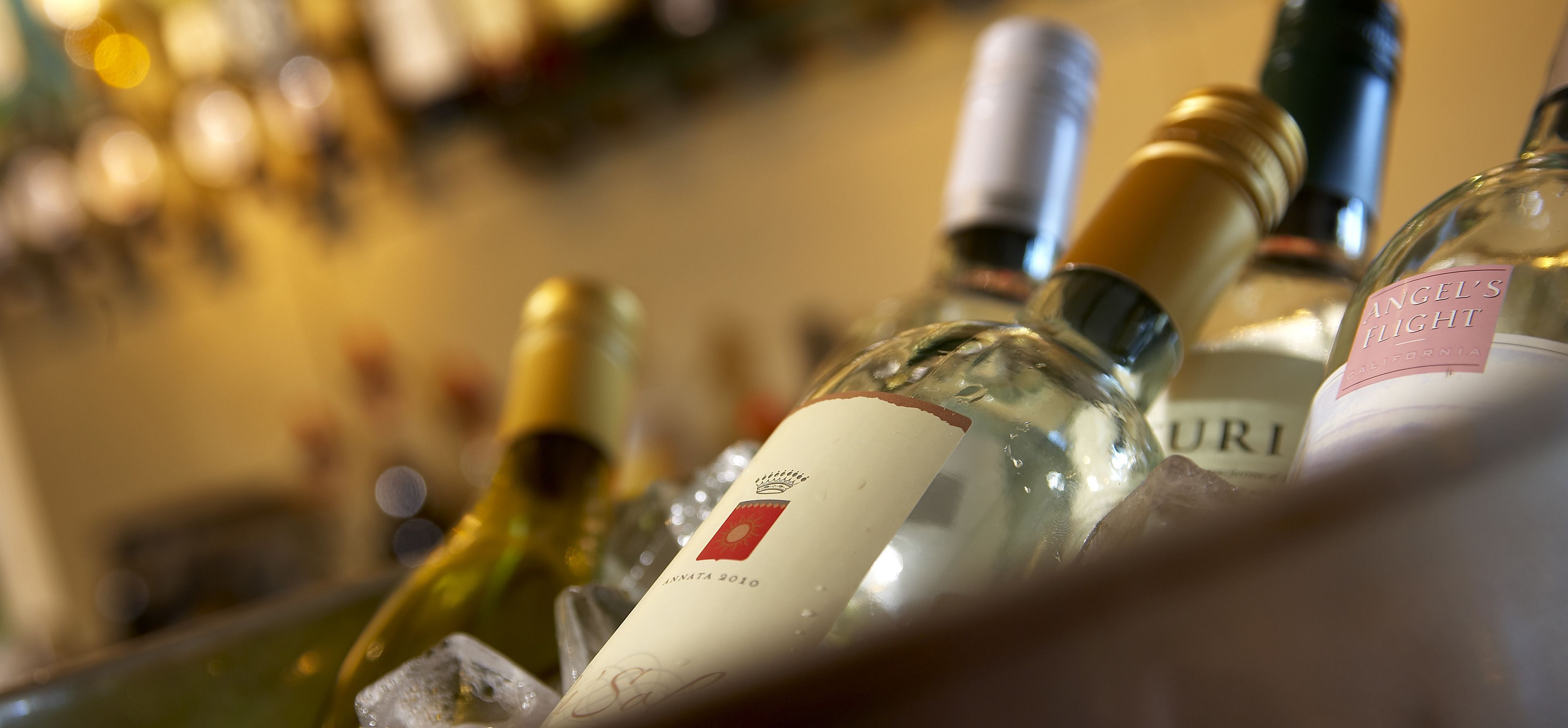 A close-up of wine bottles in a bar setting.
