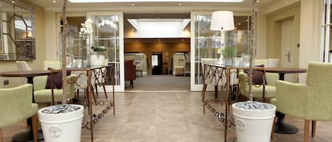A spacious lobby with a high ceiling, a central open area, and seating arrangements.