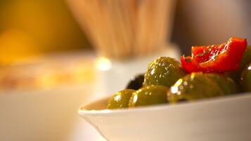 Primer plano de un plato con aceitunas y una rodaja de pimiento rojo.
