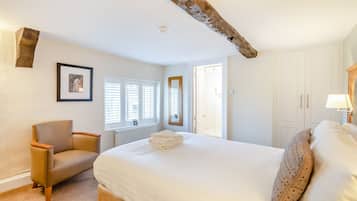 Une chambre à coucher avec un lit, une chaise, un radiateur et une fenêtre avec des stores.