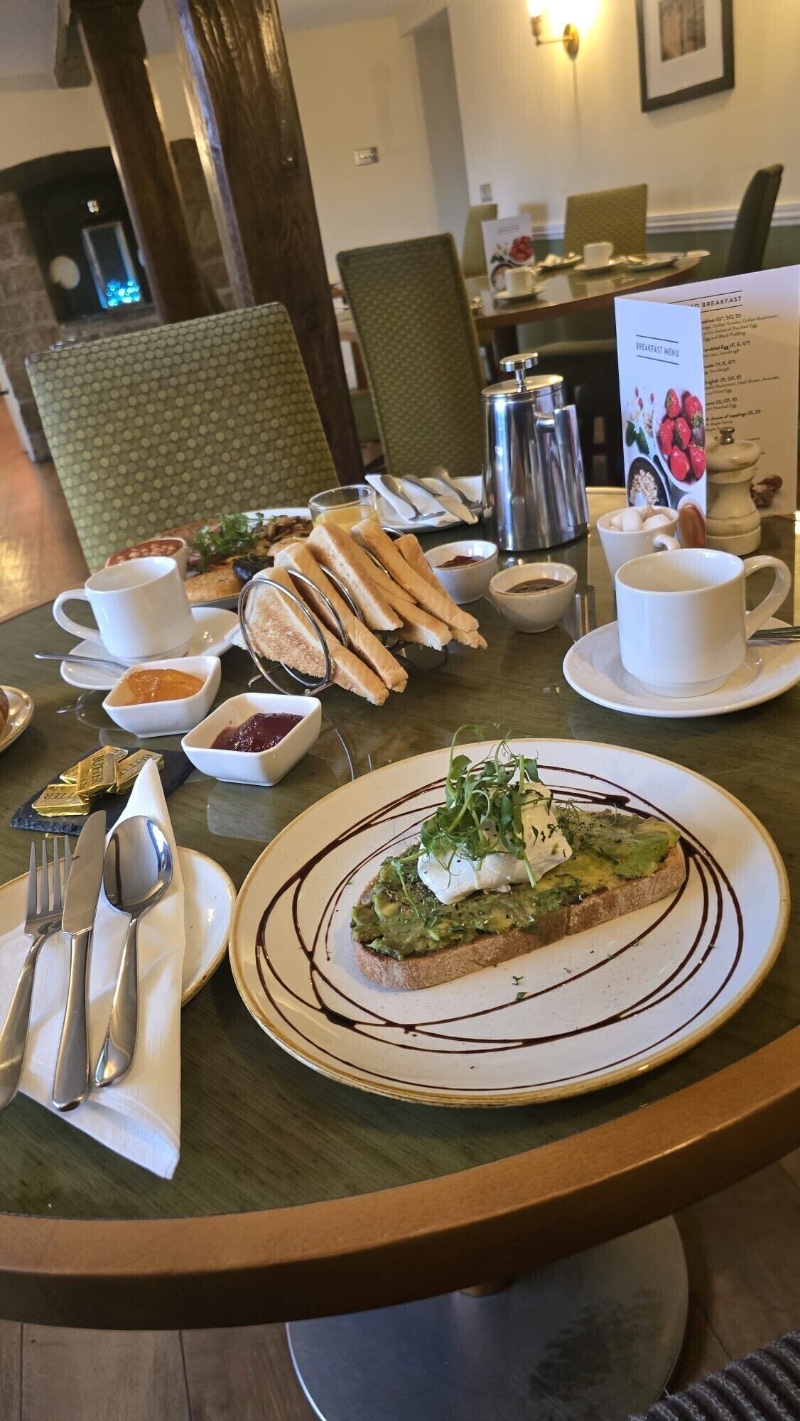 Een ontbijt met toast, jam, boter en een menukaart.