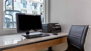 Un escritorio moderno con un monitor Dell, un teclado y una impresora HP.
