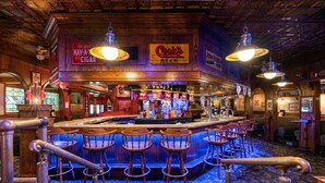 A bar area with a wooden interior, bar stools, and a sign for Cook's Goldblume beer. - Grand Vista Hotel (Grand Junction)