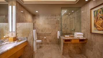 A modern bathroom with a marble vanity, a glass shower enclosure, and a large mirror.