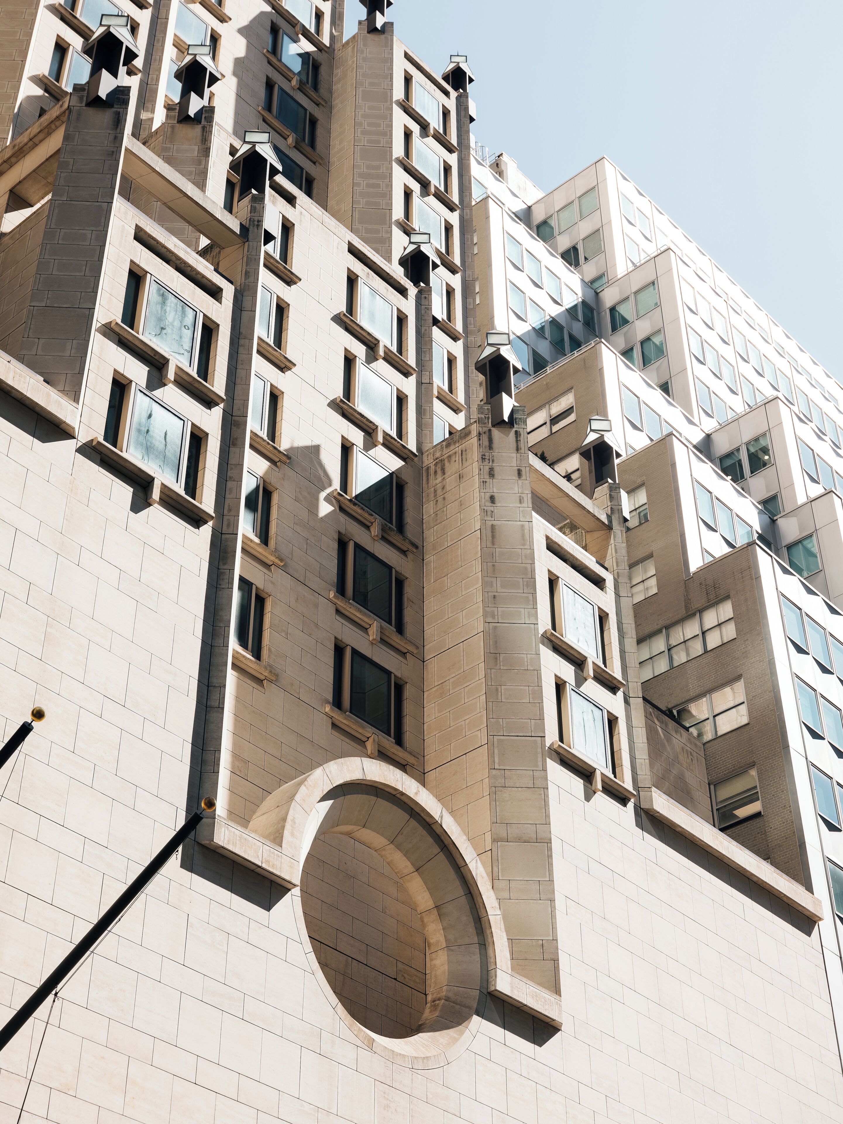 A high-rise building with a modern architectural style, featuring a prominent circular window and multiple balconies.